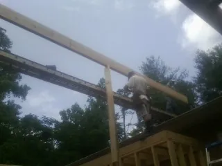 Carpenter setting a ridge beam over a new addition frame — Ice Dam Removal by Roofing Brothers in Pomeroy