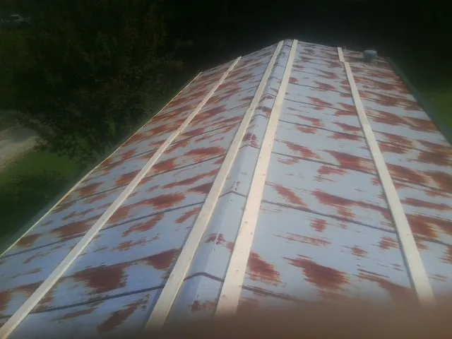 Rusted metal roof panels with new wood purlins before replacement — Storm Damage Roof Repair in Pomeroy by Roofing Brothers